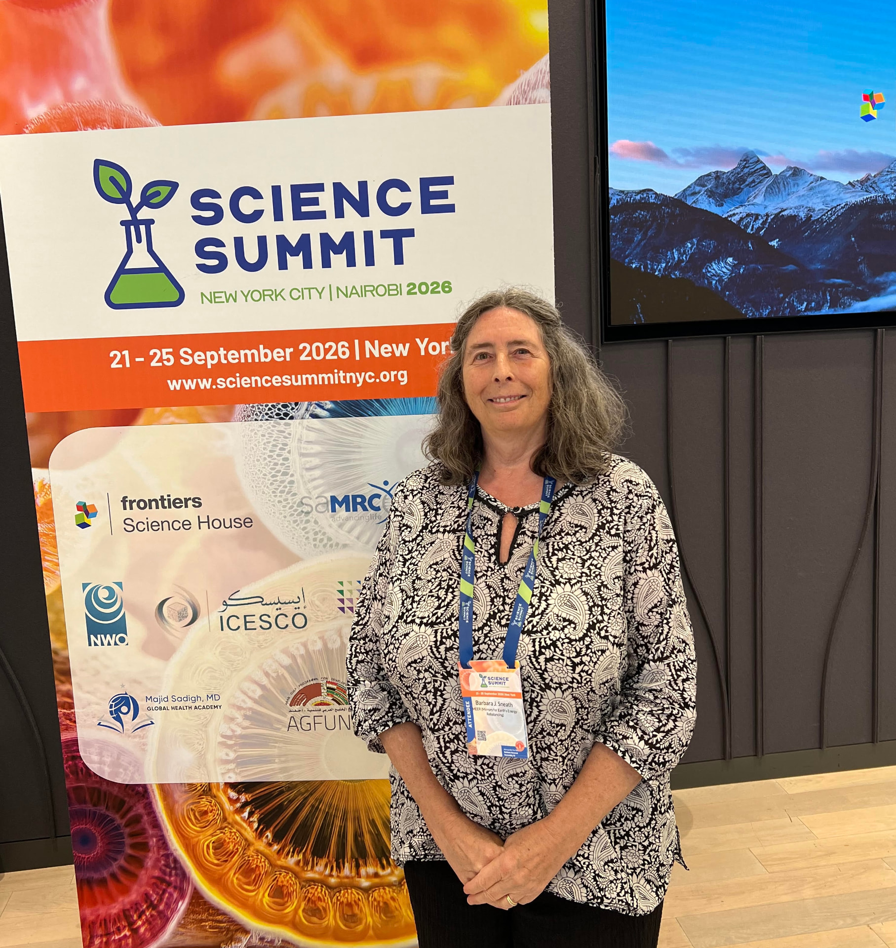 Dr. Barbara J. Sneath standing in front of the Science Summit New York City 2026 banner at the Frontiers Science House venue