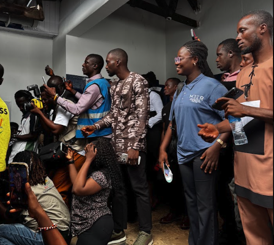 Community members and journalists recording the handing-over ceremony inside the Tombo Community Health Centre, Sierra Leone
