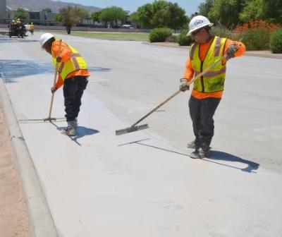 Workers finish a reflective pavement coating on a Washington DC road during the Cool Corridors pilot